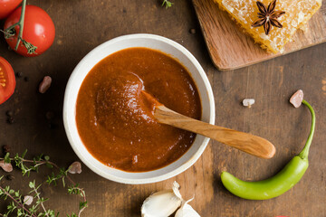 Spicy sauce with chili, lime, green tomato and tomatillo on rustic table