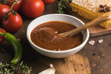 Spicy sauce with chili, lime, green tomato and tomatillo on rustic table