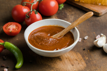 Spicy sauce with chili, lime, green tomato and tomatillo on rustic table