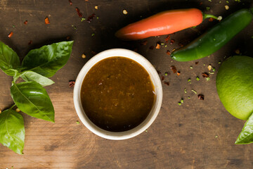 picy sauce with chili, lime, green tomato and tomatillo on rustic table