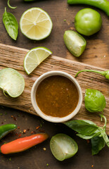 picy sauce with chili, lime, green tomato and tomatillo on rustic table