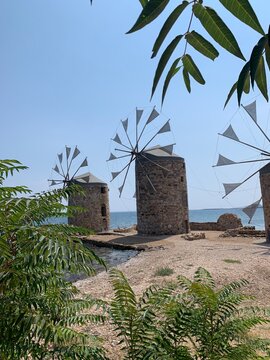 Chios Island, Greece &mdash; crystal-clear Aegean Sea, traditional stone villages, narrow alleys, pastel houses, medieval mastic villages, bright sunlight, serene coastal landscape, realistic travel photo.