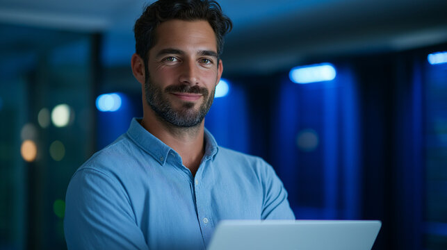A confident technician holding a laptop in a server room portrait strong stance with glowing racks in the background professional outfit illuminated by cool blue light - Powered by Adobe