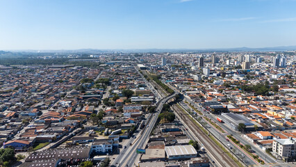 Obraz premium Vista aérea da cidade de Suzano no Alto Tietê, mostrando áreas urbanas, prédios e bairros residenciais integrados ao cenário paulista