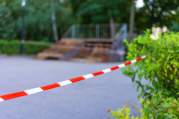 Barriers surround park site. Bright red and white barriers mark off a park area undergoing...