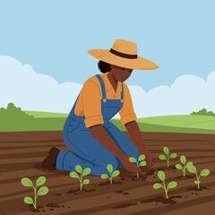 Young black woman farmer wearing overalls and straw hat tending to seedlings in a field