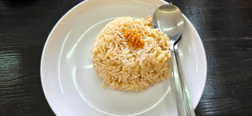 Steamed rice topped with fried garlic. Jasmine rice cooked with chicken oil, spices and broth makes rice oily, golden yellow, fragrant. Popularly eaten with boiled chicken or spicy papaya salad. 
