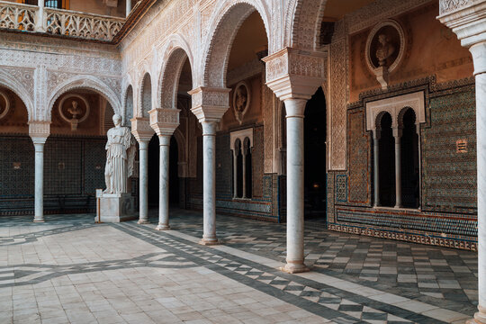 Arches and columns decorated incredible details of stucco yeseria decoration, with sebka motif, arabesques, and muqarnas sculpting - art of Moorish architecture in Casa de Pilatos, Seville, Spain.