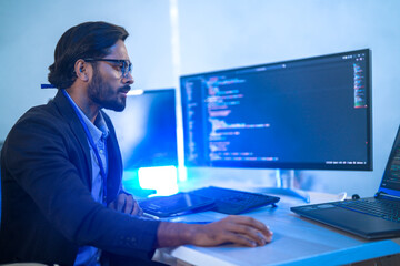 A back-end developer working on complex code in a futuristic command center. A lone programmer focused on a multi-monitor setup in a high-tech, atmospheric data hub.