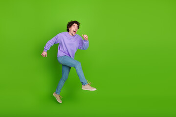 Cheerful man in purple sweater posing joyfully on bright green background with vibrant expression and colorful style
