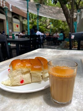 Indian chai with bun maska served at an outdoor cafe table