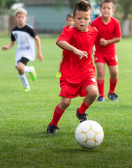 Boys kicking football on the sports field