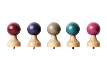 Five small, round, colored objects on wooden bases.  Each sphere is a different muted tone, including plum, deep purple, taupe, teal, and rose.  All objects are situated in a horizontal line