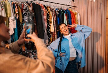 Fototapeta premium A trendy young woman confidently poses for a photo in a stylish clothing store