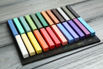 Colorful chalk pastels on wooden table, closeup