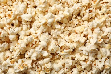 Fresh tasty popcorn as background, closeup view
