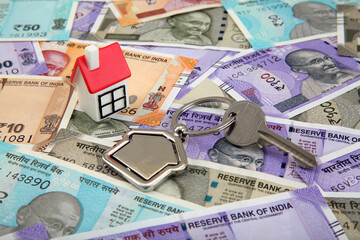 Model house and house key on Indian currency notes 