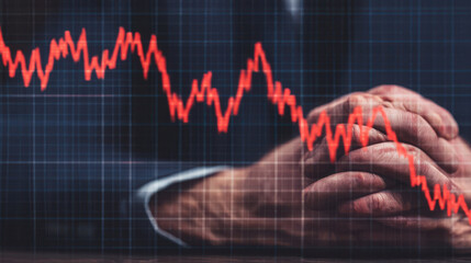 A pair of hands clasped together in front of a fluctuating red graph, symbolizing financial uncertainty or market volatility.
