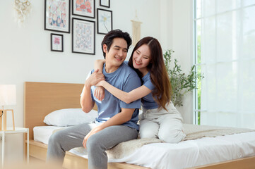 Obraz premium Happy Couple Enjoying a Cozy Moment Together in a Bright Bedroom During the Afternoon