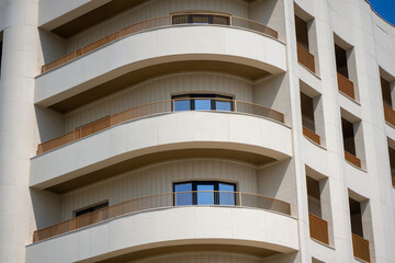 Modern residential building with rounded balconies and cream facade. Contemporary urban...