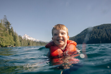 A young toddler swims in an alpine lake in the Pacific Northwest.