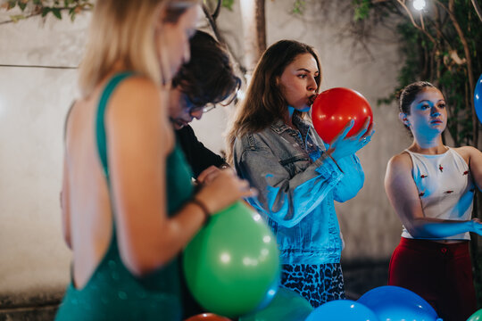 Friends collectively inflating balloons, preparing for an outdoor birthday celebration. The setting features decorated surroundings and a friendly atmosphere, evoking a sense of fun and community. - Powered by Adobe