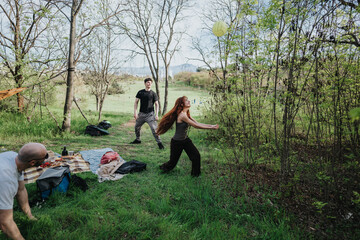 A lively group of people gather outdoors, relishing a fun day of picnicking, playing, and relaxing...