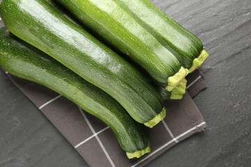 Fresh ripe zucchinis on black table, top view