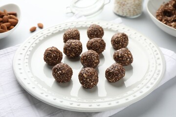 Tasty chocolate candies with nuts on white table, closeup