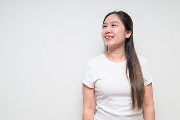 Fototapeta premium Portrait of young Asian woman thinking and looking up against white background