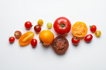 Different ripe tomatoes on white table, flat lay