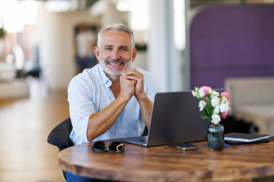 Mature businessman working on laptop at desk In office