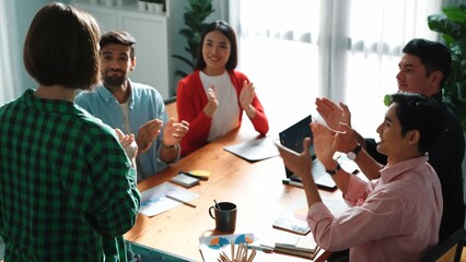 Executive manager explain marketing idea to investor while skilled diverse business team clapping hand to celebrate successful project. Skilled group applause businesswoman presentation. Convocation.