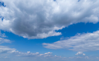 A vibrant sky featuring fluffy white clouds against a bright blue backdrop. This serene scene embodies the essence of a clear day, perfect for outdoor activities.