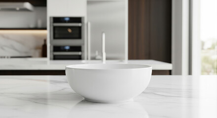 Fototapeta premium A clean white bowl sits on a marble countertop in a modern kitchen with stainless steel appliances.