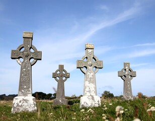 Four Celtic crosses in a graveyard under a blue sky
