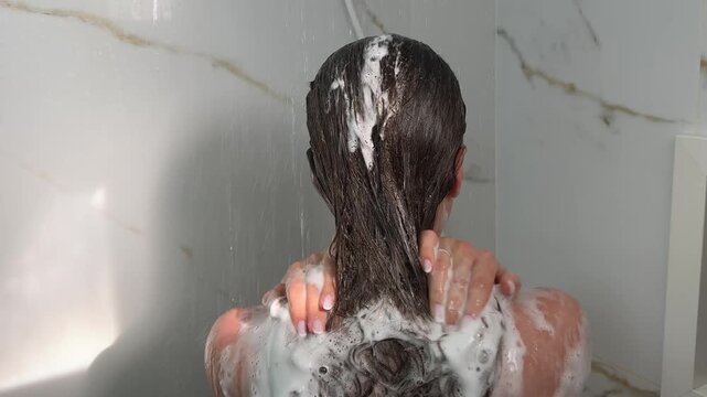 Mulher lavando cabelo no chuveiro 