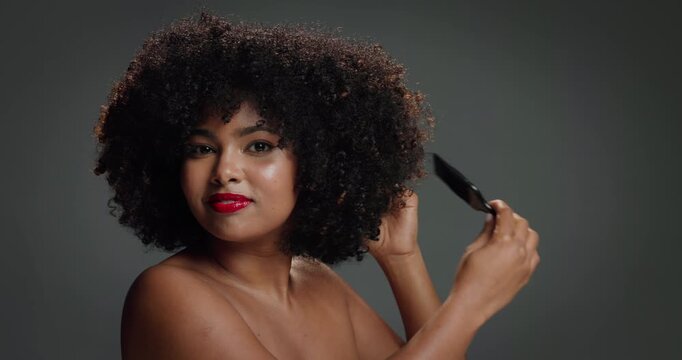 Face, woman and brush for hair care in studio for detangling, natural growth and afro volume. Portrait, African female person and comb for texture, maintenance and scalp treatment on gray background