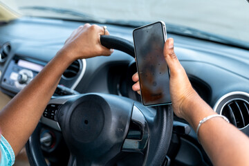 Driving with smartphone in hand near coastal road