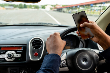 Driving with smartphone in hand near empty racetrack