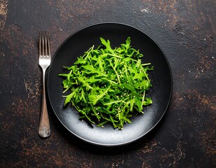 Fresh arugula salad on black plate