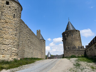 Carcassonne medieval city walls protecting towers under blue sky in France © Alberto Gonzalez 