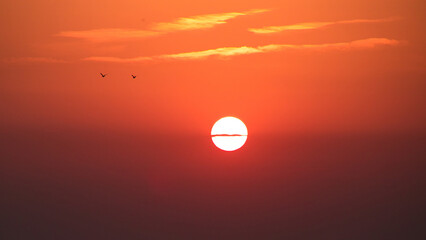 Sunset with red and orange sky and sun in center