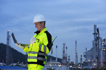 Petrochemical or refinery industry engineer working on laptop computer inspection petroleum oil...