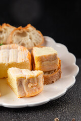 Washed rind cheese soft cheese with orange rind munster french cheese tasty snack fresh delicious gourmet food background on the table rustic top view copy space