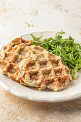 Zucchini waffles served with arugula salad close up. Healthy vegeterian food