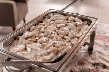 buffet table with chicken in white sauce