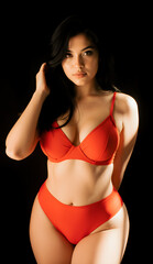 Fototapeta premium Beautiful woman with black hair in red lingerie on dark background, fashion portrait