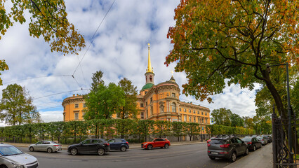 Panoramic view of Mikhailovsky Castle in romantic classicism style with autumn trees and framing branches. Saint Petersburg, Russia.