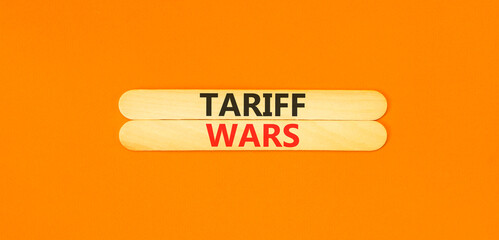 Trade tariff wars symbol. Concept word Tariff wars on beautiful wooden sticks. Beautiful orange paper background. Business trade tariff wars concept. Copy space.
